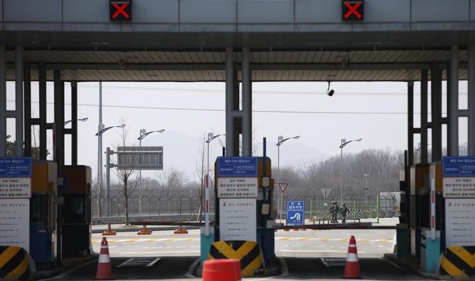 South Korean soldiers walk on an empty road connecting the Kaesong Industrial Complex (KIC) with South Korea's CIQ (Customs, Immigration and Quarantine), just south of the demilitarised zone separating the two Koreas, in Paju, north of Seoul, April 3, 2013. North Korean authorities were not allowing any South Korean workers into a joint industrial park on Wednesday, South Korea's Unification Ministry and a Reuters witness said, adding to tensions between the two countries. REUTERS/Kim Hong-Ji (SOUTH KOREA - Tags: MILITARY POLITICS BUSINESS) Published: Dub. 3, 2013, 4:46 dop.