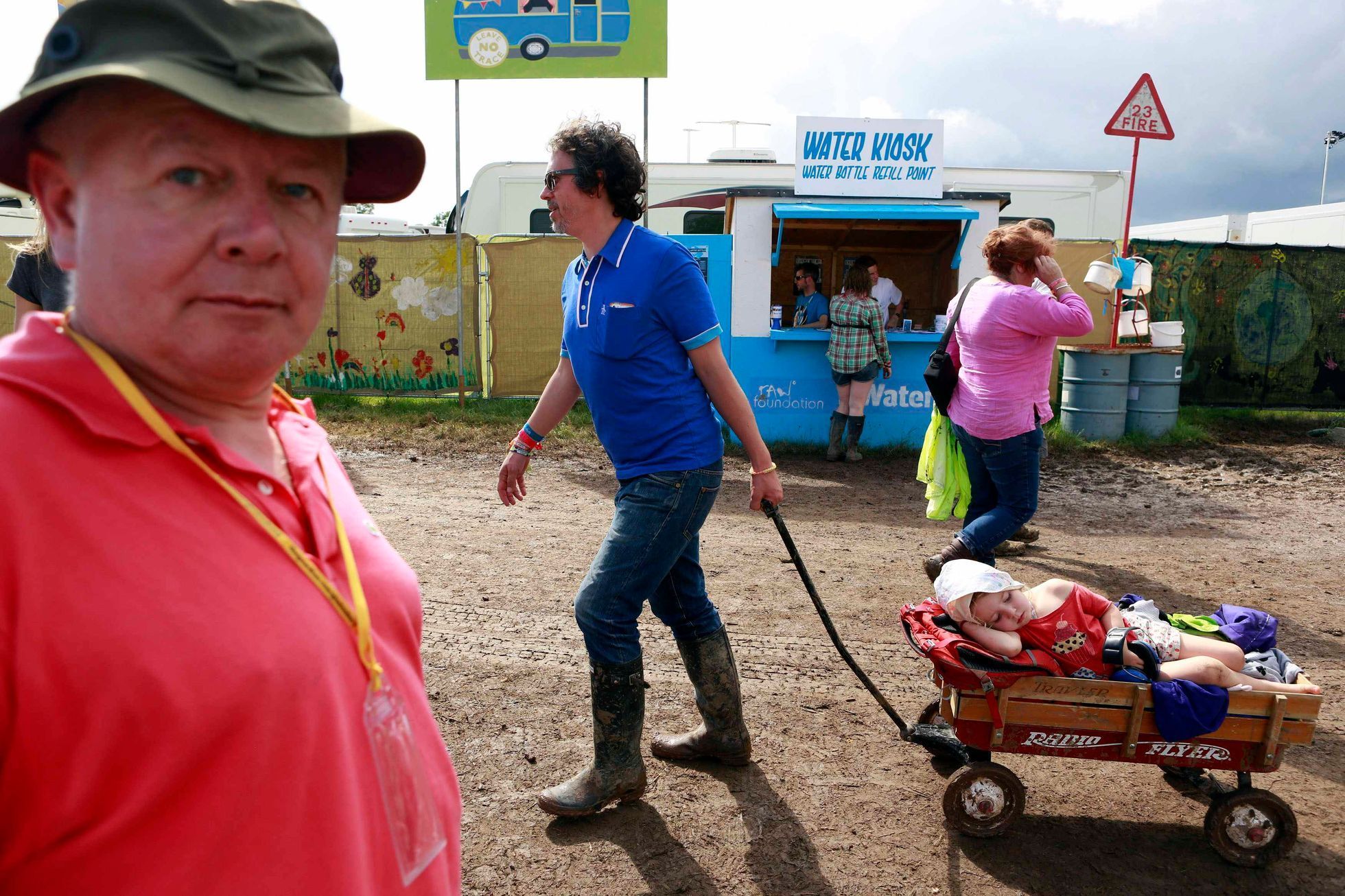 A man pulls his child in a trailer around Worthy Farm in Somerset, during the Glastonbury Festival