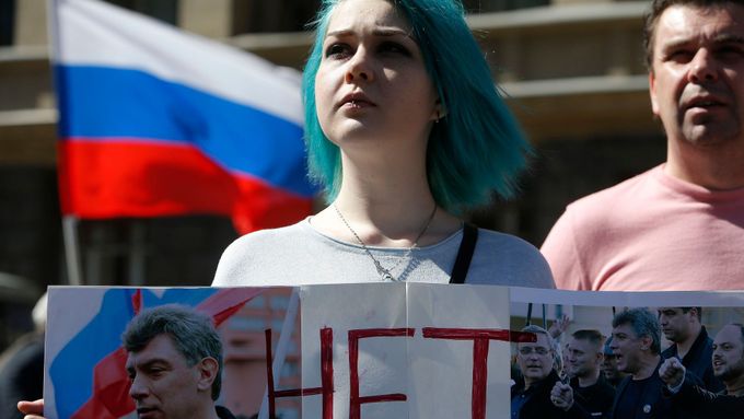 Mladá Ruska na protivládní demonstraci drží banner s portrétem zavražděného opozičníka Němcova.
