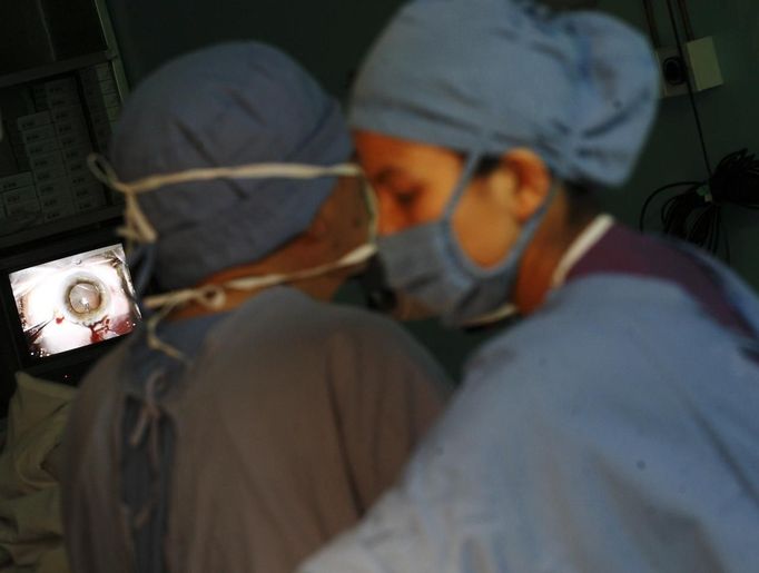 The eye of patient is pictured on a television screen while surgeon Sanduk Ruit operates during a cataract surgery at the Tilganga Eye Center in Kathmandu April 25, 2012. Ruit, a Nepali national at the Tilganga Eye Centre, pioneered a simple eye operation benefiting tens of thousands of people in Nepal and other countries in Asia and Africa, where surgical teams from the centre provide much needed care in field camps. Picture taken April 25, 2012. REUTERS/Navesh Chitrakar (NEPAL - Tags: HEALTH SOCIETY POVERTY) Published: Kvě. 2, 2012, 5:33 dop.