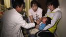 A doctor at a clinic in temporary housing complex Shunji Sekine (L) conducts a thyroid examination on a child in Nihonmatsu, about 50 km (31 miles) from the tsunami-crippled Fukushima Daiichi nuclear power plant, Fukushima prefecture February 25, 2013, ahead of the second-year anniversary of the March 11, 2011 earthquake and tsunami. As the World Health Organisation (WHO) says children in Fukushima may have a higher risk of developing thyroid cancer after the Daiichi nuclear disaster two years ago, mothers in Fukushima worry that local health authorities are not doing enough. Picture taken February 25, 2013. REUTERS/Chris Meyers (JAPAN - Tags: DISASTER HEALTH) Published: Úno. 28, 2013, 2:50 odp.