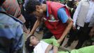 A rescue worker comforts a survivor, who was trapped inside the rubble of the collapsed Rana Plaza building, in Savar, 30 km (19 miles) outside Dhaka April 25, 2013. The death toll from a building collapse in Bangladesh has risen to 160 and could climb higher, police said on Thursday, with people trapped under the rubble of a complex that housed garment factories supplying retailers in Europe and North America. REUTERS/Andrew Biraj (BANGLADESH - Tags: DISASTER) Published: Dub. 25, 2013, 5:45 dop.