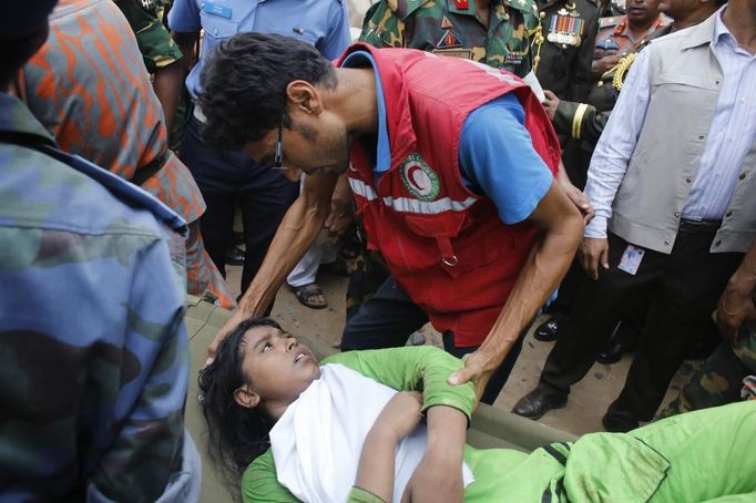 A rescue worker comforts a survivor, who was trapped inside the rubble of the collapsed Rana Plaza building, in Savar, 30 km (19 miles) outside Dhaka April 25, 2013. The death toll from a building collapse in Bangladesh has risen to 160 and could climb higher, police said on Thursday, with people trapped under the rubble of a complex that housed garment factories supplying retailers in Europe and North America. REUTERS/Andrew Biraj (BANGLADESH - Tags: DISASTER) Published: Dub. 25, 2013, 5:45 dop.