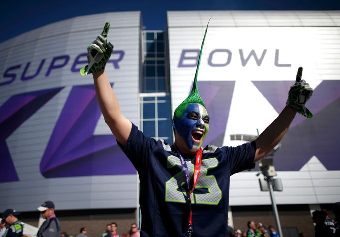 A Seattle Seahawks fan celebrates while awaiting the start of the NFL Super Bowl XLIX football game against the New England Patriots outside of the stadium in Glendale, A