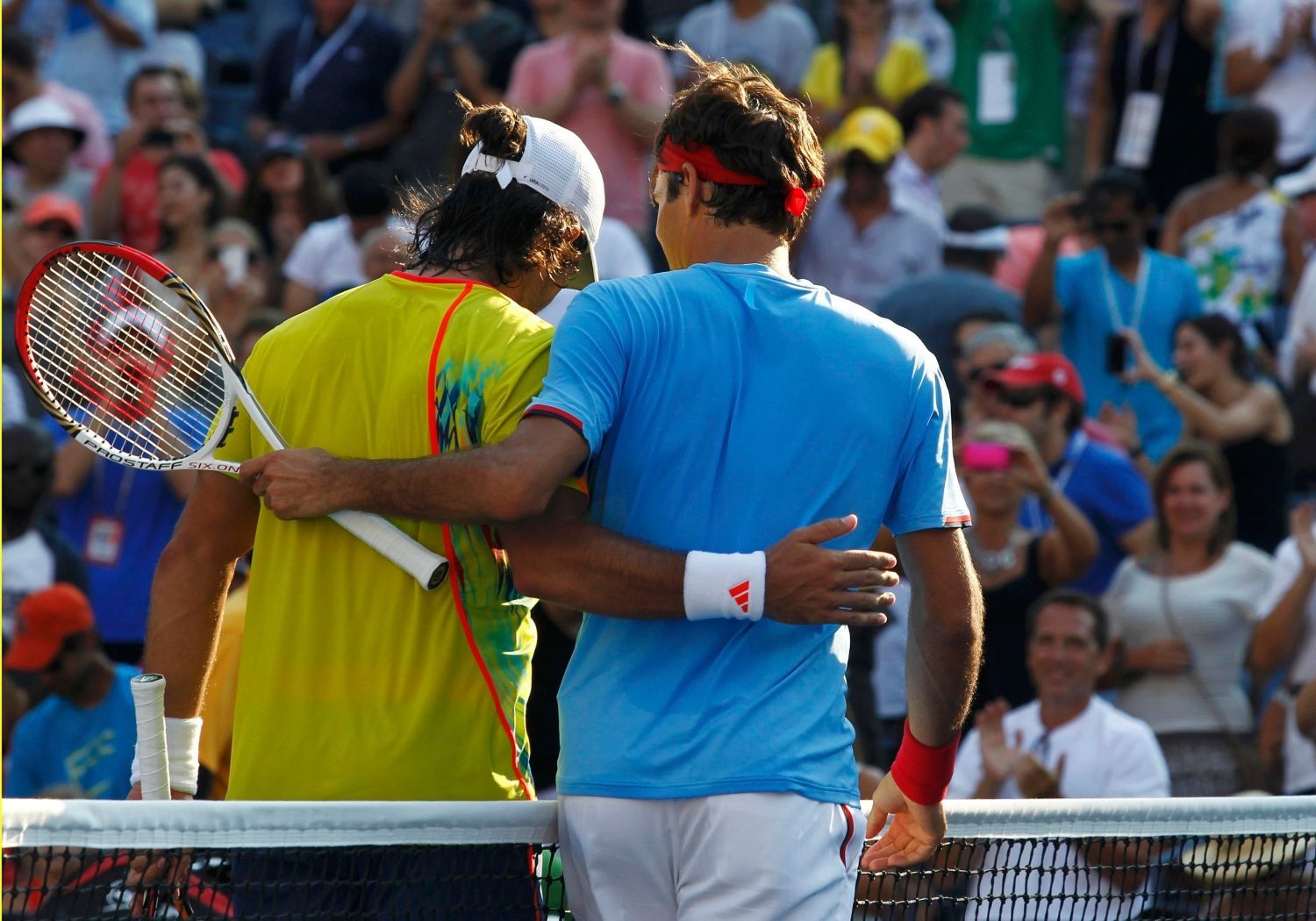 Švýcarský tenista Roger Federer utěšuje poraženého Španěla Fernanda Verdasca ve 3. kole US Open 2012.