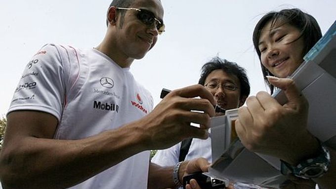 Usměvavý Lewis Hamilton rozdává autogramy svým čínským fanouškům před závodem v Šanghaji.