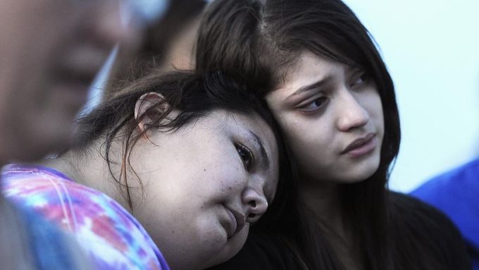 Mary Hamilton (L) puts her head on the shoulder of her friend Stephanie Rodriquez during a vigil for victims behind a theater where a gunman open fire on moviegoers in Aurora, Colorado July 20, 2012. A total of 71 people were shot in Friday's rampage at the Denver-area movie theater that has left 12 people dead, the local police chief said. The suspect, identified by police as James Eagan Holmes, 24, also booby-trapped his Aurora apartment with sophisticated explosives, creating a hazard for law-enforcement and bomb squad officers who swarmed to the scene. REUTERS/ Jeremy Papasso (UNITED STATES - Tags: CRIME LAW TPX IMAGES OF THE DAY) Published: Čec. 21, 2012, 3:48 dop.