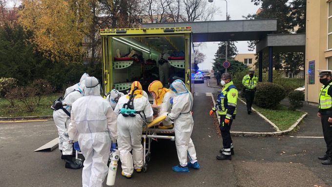 Zdravotníci nakládají posledního pacienta k převozu z benešovské nemocnice do FN Motol v Praze.