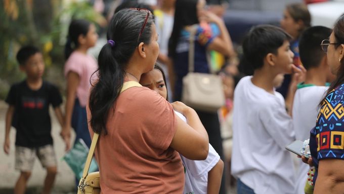 Žena objímá dítě, zatímco rodiče a děti se evakuují po silném zemětřesení ve městě Davao na Filipínách v pátek 10. října 2025. (AP Photo/Manman Dejeto)
