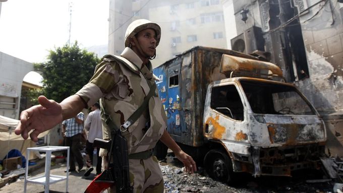Egyptský voják před vypálenou mešitou v Káhiře. Uvnitř zůstaly stovky mrtvých, úřady je údajně nezapočítávají do tragické bilance.