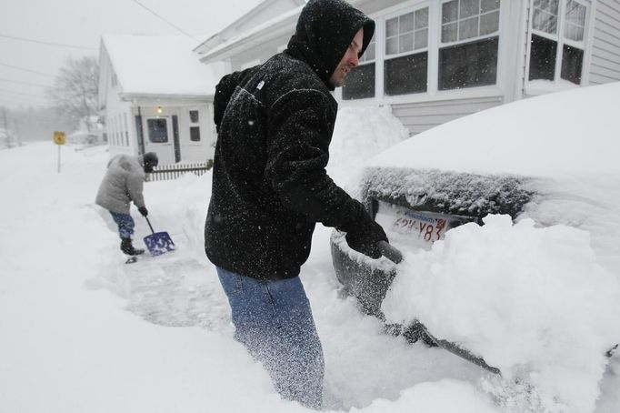 Kevin Connolley (R) and his father Ed, work to clear the sidewalk of snow during a blizzard in Medford, Massachusetts February 9, 2013. REUTERS/Jessica Rinaldi (UNITED STATES - Tags: ENVIRONMENT) Published: Úno. 9, 2013, 3:12 odp.