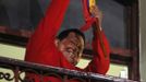 Venezuelan President Hugo Chavez holds the national flag while celebrating from a balcony at the Miraflores Palace in Caracas October 7, 2012. Venezuela's socialist President Chavez won re-election in Sunday's vote with 54 percent of the ballot to beat opposition challenger Henrique Capriles. REUTERS/Tomas Bravo (VENEZUELA - Tags: POLITICS ELECTIONS) Published: Říj. 8, 2012, 6:22 dop.