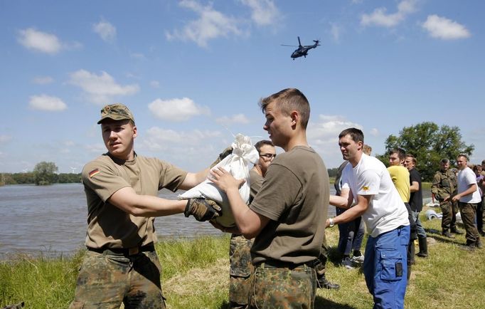 German Bundeswehr armed forces soldiers and volunteers carry sandbags on a damaged dyke at the river Elbe at the village of Hohengoehren, north of Magdeburg June 10, 2013. Tens of thousands of people have been forced to leave their homes and there have been at least a dozen deaths as a result of floods that have hit Germany, Austria, Slovakia, Poland and the Czech Republic over the past week. REUTERS/Fabrizio Bensch (GERMANY - Tags: DISASTER ENVIRONMENT)