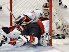Calgarský obránce Roman Hamrlík při pádu zatlačil do branky svého gólmana Miikku Kiprusoffa.