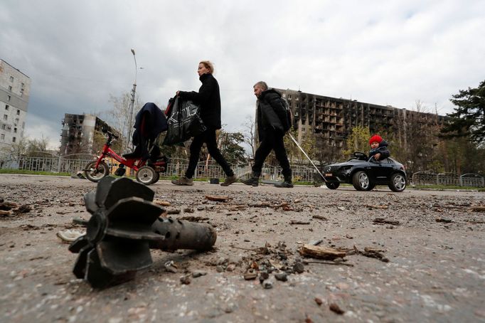 Tříčlenná rodina s malým dítětem kráčí ulicí přístavného města Mariupol. Jen  pár kroků od nich leží střela.