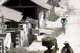 ...vesničané procházejí ulicí ve vesnici Babadan, střechy domů jsou zde zasypány popílkem...