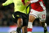 Carlos Vela z Arsenalu se snaží utéct Emmersonu Boycovi z Wiganu