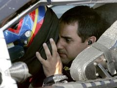 Kolumbijský pilot Juan Pablo Montoya si nasazuje přilbu před startem závodu série NASCAR Ford 400. Závod nedokončil kvůli havárii.