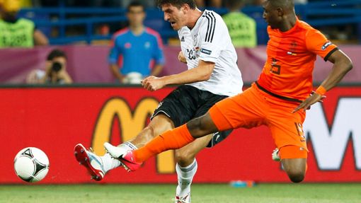 Mario Gómez střílí svůj druhý gól během utkání Nizozemska s Německem přes Jetra Willemse ve skupině B na Euru 2012.
