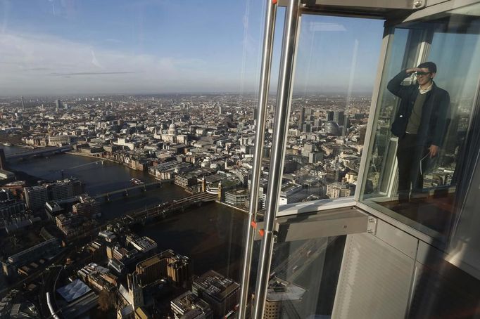 ATTENTION EDITORS - EMBARGOED FOR PUBLICATION TO 00:01 GMT JANUARY 11, 2013 An employee poses at a window in The View gallery at the Shard, western Europe's tallest building, in London January 9, 2013. The View, the public viewing deck accessible by high speed elevators on the 309 metre (1013 feet) Shard building, opens on February 1. Picture taken January 9, 2013. REUTERS/Luke Macgregor (BRITAIN - Tags: TRAVEL CITYSCAPE) TEMPLATE OUT Published: Led. 10, 2013, 12:07 odp.