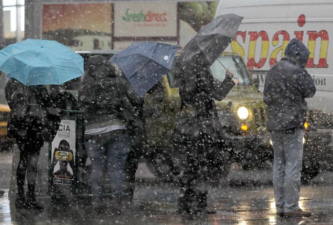 People wait at at a bus stop in the wind and snow in New York's Times Square, November 7, 2012. A wintry storm dropped snow on the Northeast and threatened to bring dangerous winds and flooding to a region still climbing out from the devastation of superstorm Sandy. REUTERS/Brendan McDermid (UNITED STATES - Tags: DISASTER ENVIRONMENT) Published: Lis. 7, 2012, 8:22 odp.