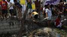 Residents stand in front of a wooden cross on which penitent had been hung during a Good Friday crucifixion re-enactment in San Juan village, Pampanga province, north of Manila March 29, 2013. About two dozen Filipinos were nailed to crosses on Good Friday in an extreme display of devotion that the Catholic church looks down upon as a form of folk religion but appears powerless to stop. Holy Week is celebrated in many Christian traditions during the week before Easter. REUTERS/Romeo Ranoco (PHILIPPINES - Tags: RELIGION SOCIETY) Published: Bře. 29, 2013, 10:32 dop.