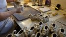 A worker uses a sponge to wipe down a cow shaped creamer jug at the Middleport pottery in Stoke-on-Trent, central England January 22, 2013. The pottery which dates back to 1888 and was rescued from closure in 2009, continues to use traditional methods to produce its range of ceramics and famous Burleigh Ware pottery. REUTERS/Phil Noble (BRITAIN - Tags: BUSINESS EMPLOYMENT SOCIETY) Published: Led. 22, 2013, 4:23 odp.