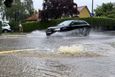 A car drives through a flooded street after the river Schmutter burst it banks, following heavy rainfalls in Fischach, near Augsburg, Germany, June 1, 2024. REUTERS/Ayhan