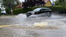 A car drives through a flooded street after the river Schmutter burst it banks, following heavy rainfalls in Fischach, near Augsburg, Germany, June 1, 2024. REUTERS/Ayhan