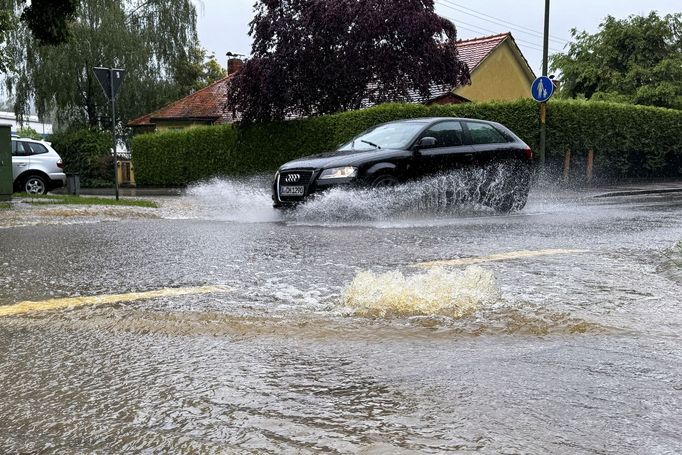 A car drives through a flooded street after the river Schmutter burst it banks, following heavy rainfalls in Fischach, near Augsburg, Germany, June 1, 2024. REUTERS/Ayhan