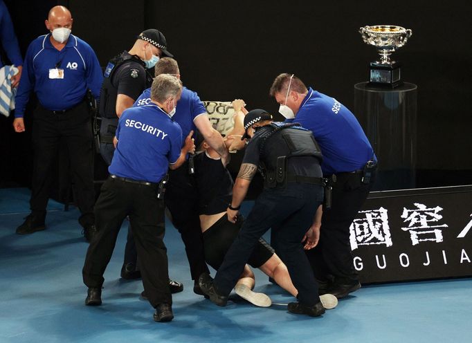Ochranka spolu s policisty odtahuje výtržníka, který vběhl na kurt během finále Australian Open 2022