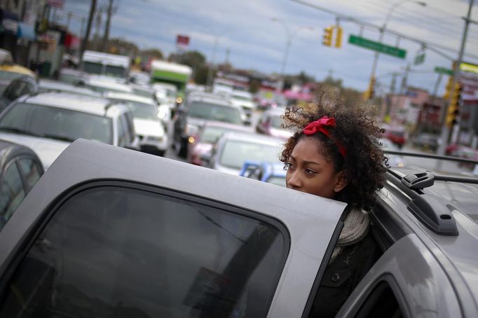 A girl looks toward a gas station as she and her parents wait with hundreds of others for over three hours to fuel up their vehicles in the New York City borough of Queens on November 1, 2012. A fuel supply crisis stalling the New York City area's recovery from Hurricane Sandy and reviving memories of the 1970s gasoline shortages stem from multiple factors, ranging from flooding to power outages to a diesel spill. REUTERS/Adrees Latif (UNITED STATES - Tags: DISASTER ENVIRONMENT ENERGY) Published: Lis. 1, 2012, 8:49 odp.