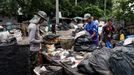 Barmští dělníci ručně třídí shnilý potravinový odpad, textilie a recyklovatelný plast na třídicí stanici v Bangkoku, Thajsko, 22. července 2024.