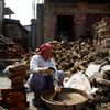 Žena v Bhaktapuru sbírá cihly ze zřícenin domu, kde dříve bydlela.