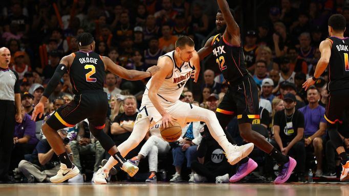 May 7, 2023; Phoenix, Arizona, USA; Denver Nuggets center Nikola Jokic (15) drives to the basket against Phoenix Suns center Deandre Ayton (22) and forward Josh Okogie (2