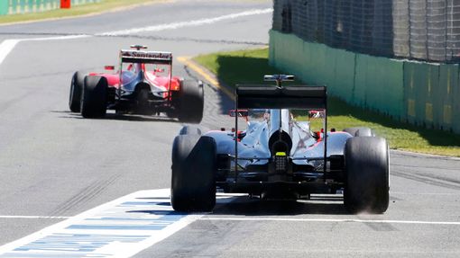 Ferrari Formula One driver Kimi Raikkonen of Finland (front) and McLaren driver Jenson Button of Britain leave the pit lane during the first practice session of the Austr