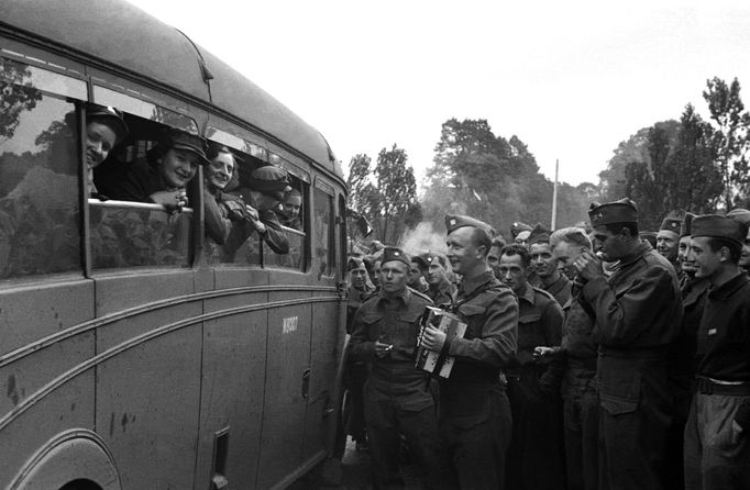 Návštěva děvčat z britských pomocných sborů v Cholmondeley v roce 1940. S harmonikou pozdější radiotelegrafista a pilot 311. čs. bombardovací perutě RAF Jiří Osolsobě.