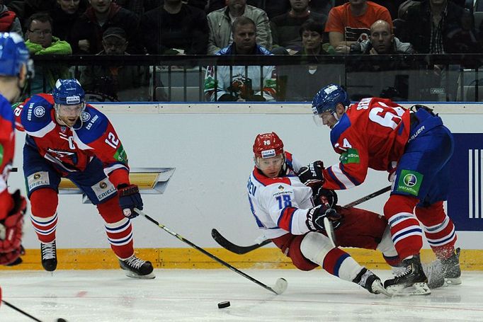 Hokejisté Lva Praha Jiří Novotný (vlevo) a Jiří Sekáč v souboji s Dmitrijem Kugryševem v utkání KHL proti CSKA Moskva.