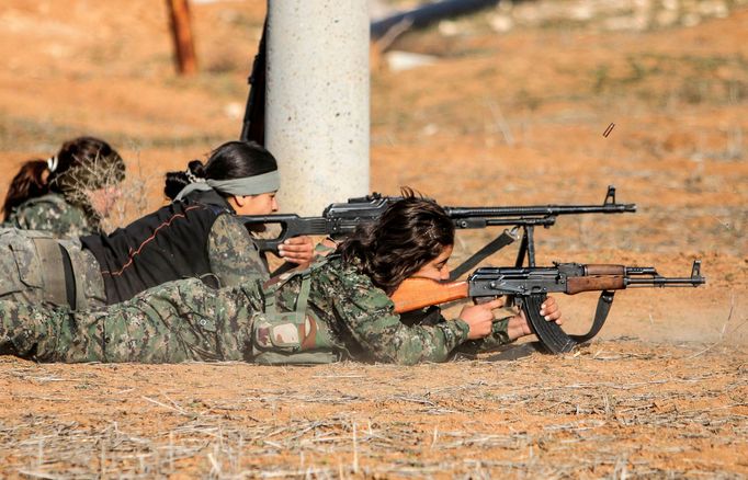 A female fighter of the Kurdish People's Protection Units (YPG) fires a Rocket-propelled grenade (RPG) as she participates in a military training