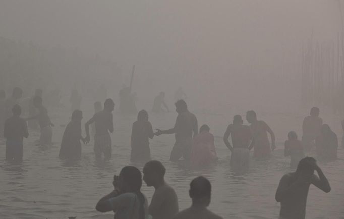 Hindu devotees take a holy dip in the waters of river Ganges amid fog ahead of the "Kumbh Mela" (Pitcher Festival) in the northern Indian city of Allahabad January 13, 2013. During the festival, Hindus take part in a religious gathering on the banks of the river Ganges. "Kumbh Mela" will return to Allahabad in 12 years. REUTERS/Ahmad Masood (INDIA - Tags: ENVIRONMENT SOCIETY RELIGION) Published: Led. 13, 2013, 7:08 dop.