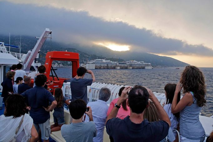 The Costa Concordia cruise liner (in background) is pictured from a ferry as it emerges during the refloating operation at Giglio harbour July 20, 2014.