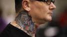 A visitor shows off his neck tattoo at the Hampton Roads Tattoo Festival in Virginia March 3, 2012. The hobby of collecting tattoos has exploded into the mainstream of society with tattoo conventions and festivals held year-round across the United States and the world. Picture taken March 3, 2012. REUTERS/Larry Downing (UNITED STATES - Tags: SOCIETY) ATTENTION EDITORS PICTURE 15 OF 31 FOR PACKAGE 'ADDICTED TO THE NEEDLE' TO FIND ALL PICTURES SEARCH 'ADDICTED NEEDLE' Published: Čer. 29, 2012, 12:59 odp.