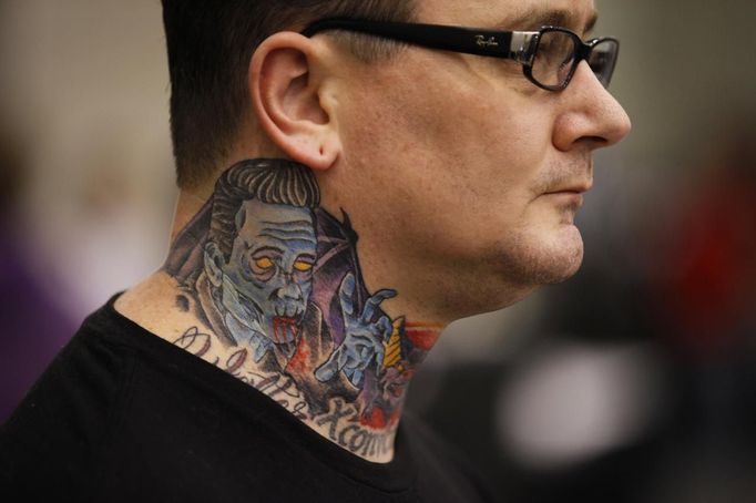 A visitor shows off his neck tattoo at the Hampton Roads Tattoo Festival in Virginia March 3, 2012. The hobby of collecting tattoos has exploded into the mainstream of society with tattoo conventions and festivals held year-round across the United States and the world. Picture taken March 3, 2012. REUTERS/Larry Downing (UNITED STATES - Tags: SOCIETY) ATTENTION EDITORS PICTURE 15 OF 31 FOR PACKAGE 'ADDICTED TO THE NEEDLE' TO FIND ALL PICTURES SEARCH 'ADDICTED NEEDLE' Published: Čer. 29, 2012, 12:59 odp.