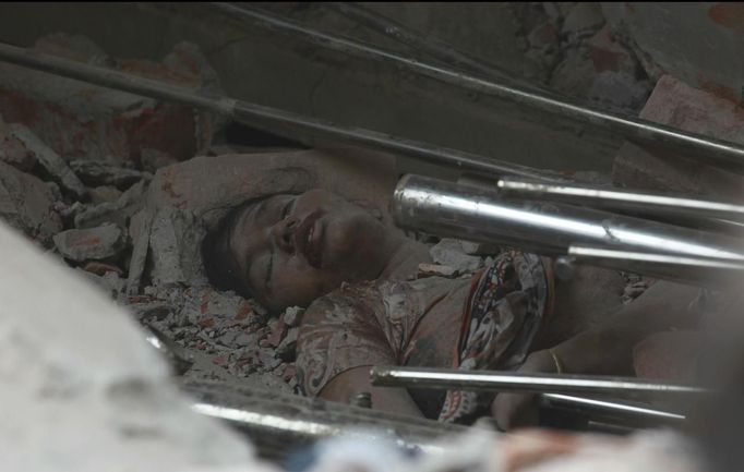 The body of a garment worker is seen amongst the rubble of the collapsed Rana Plaza building in Savar, 30 km (19 miles) outside Dhaka April 24, 2013. The eight-storey block housing factories and a shopping centre collapsed on the outskirts of the Bangladeshi capital on Wednesday, killing more than 70 people and injuring hundreds, a government official said. REUTERS/Andrew Biraj (BANGLADESH - Tags: DISASTER BUSINESS) Published: Dub. 24, 2013, 9:25 dop.