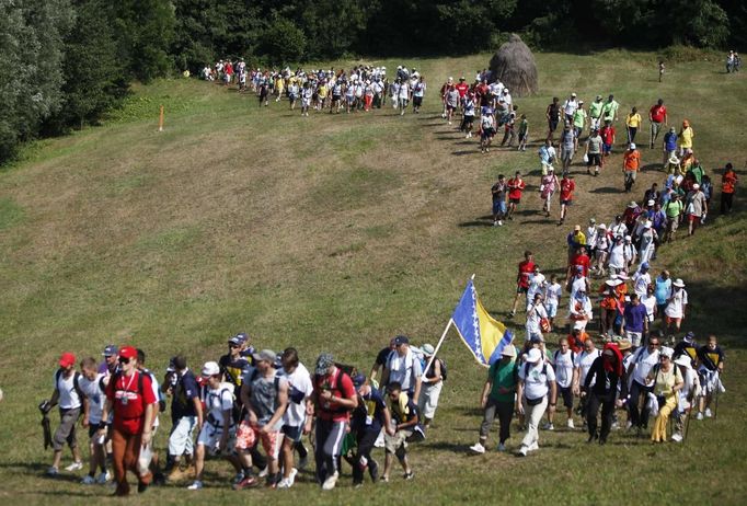 People walk through a forest near the village of Nezuk, about 150 km (93 miles) from capital of Sarajevo, July 8, 2012. Several thousand people on Sunday started a 85 km (53 mile) march from Nezuk to Srebrenica called the "March of Peace", to retrace the route in reverse taken by Bosnian Muslims who fled Serb forces who slaughtered 8,000 of their Muslim kin in 1995. The participants in the march consisted of survivors of the Srebrenica massacre as well as people from all parts of Bosnia and countries around the world. REUTERS/Dado Ruvic (BOSNIA AND HERZEGOVINA - Tags: POLITICS SOCIETY) Published: Čec. 8, 2012, 10:09 dop.