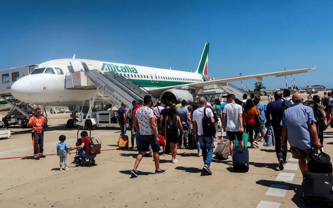 Pasažéři v Cagliari nastupují do letadlo italských aeroliní Alitalia.