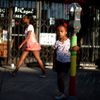 Mahlet Mogas stands with an arm around a parking meter decorated with wool in the colours of the Ethiopian flag in the Little Ethiopia area of Los Angeles, California