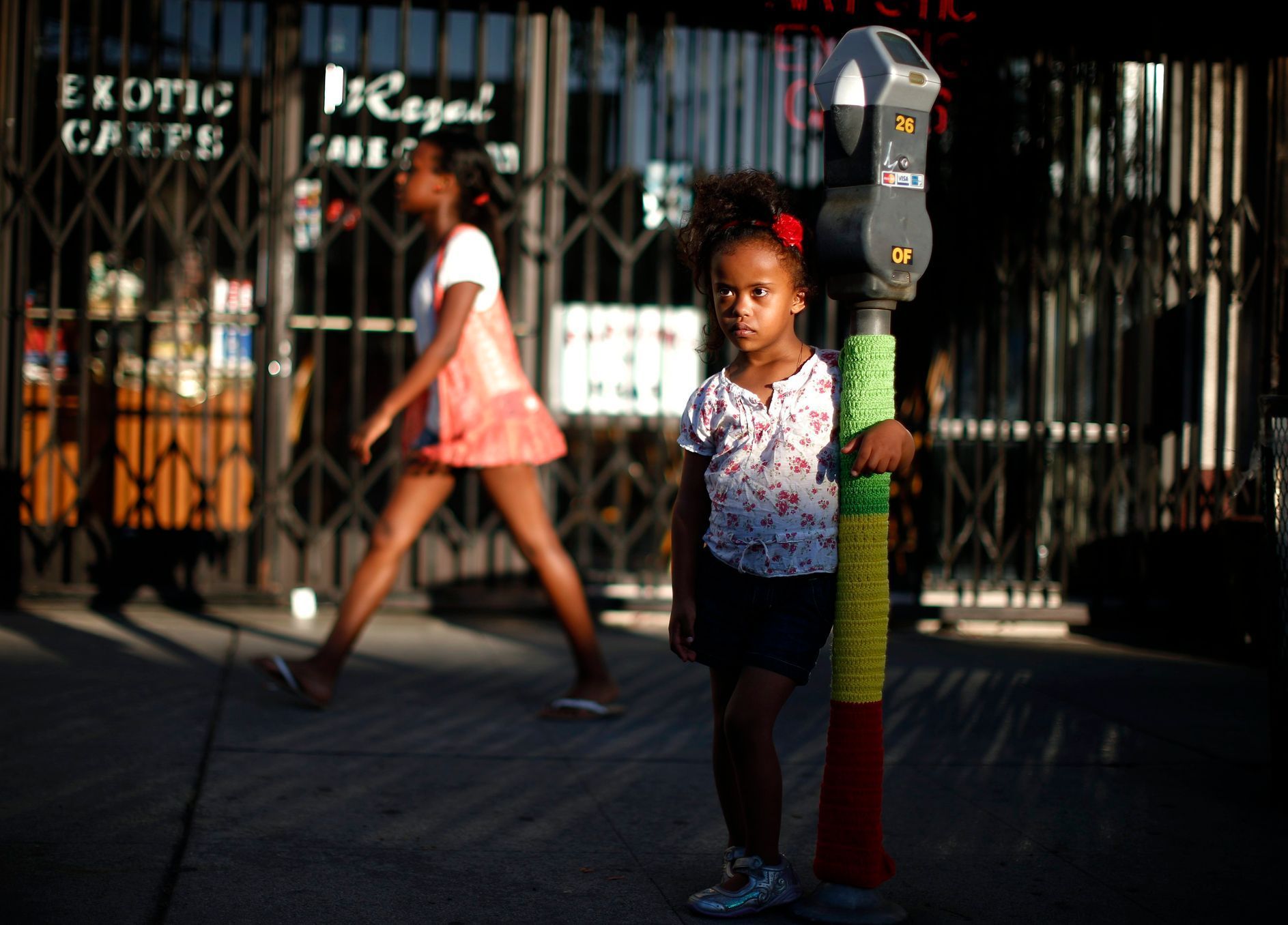 Mahlet Mogas stands with an arm around a parking meter decorated with wool in the colours of the Ethiopian flag in the Little Ethiopia area of Los Angeles, California