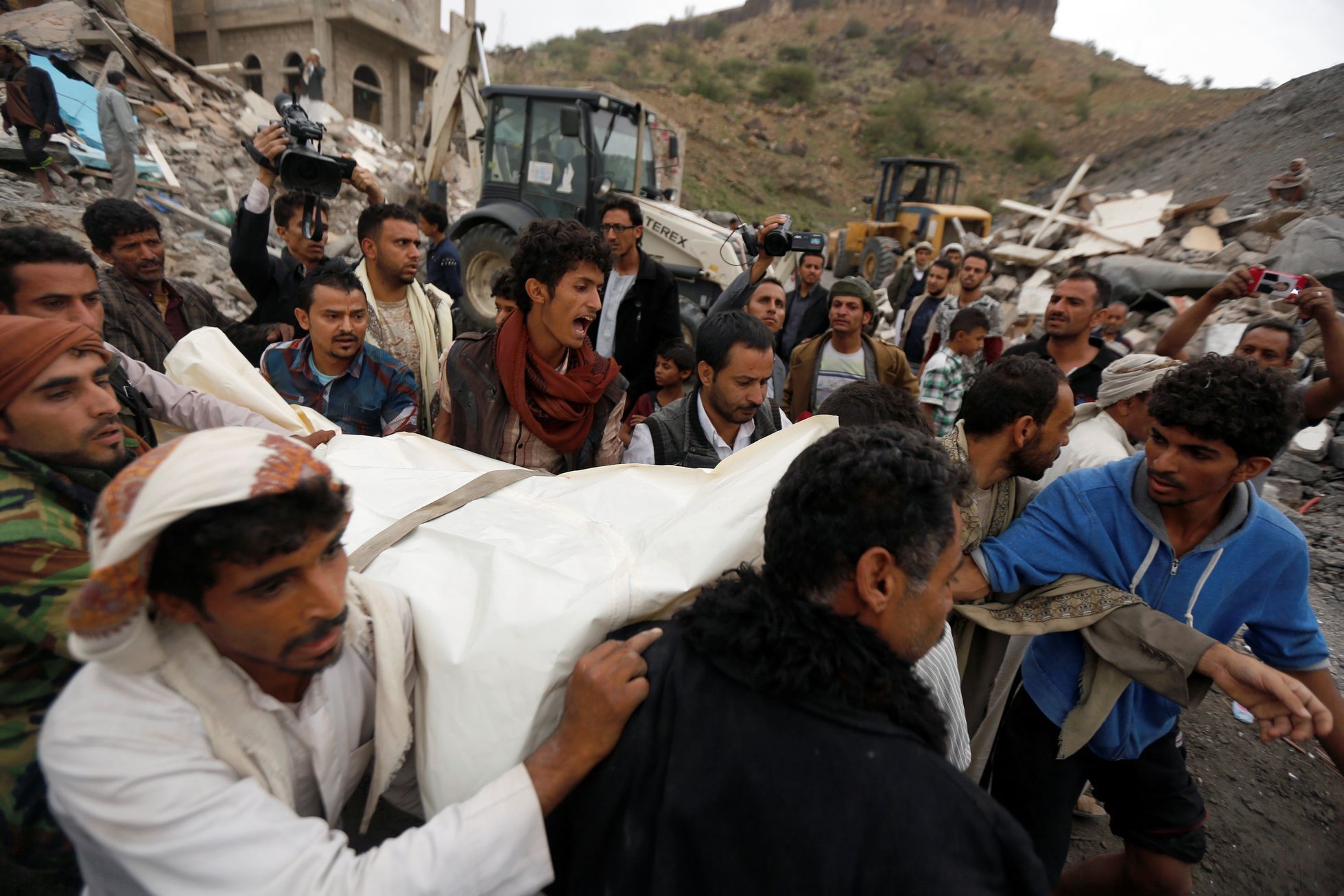 Lidé odnášejí oběti po náletu v Jemenu.