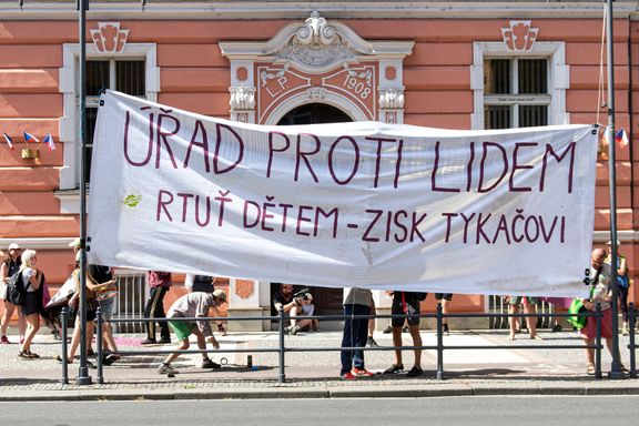 Transparent s nápisem "Uřad proti lidem. Rtuť dětem - zisk Tykačovi" demonstranti upevnili na stožáry veřejného osvětlení.